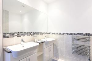 een badkamer met 2 wastafels en een spiegel bij Glas Mor in Carbis Bay