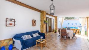 a living room with a blue couch and a table at Casa Rural VILLAMADA in El Real de la Jara