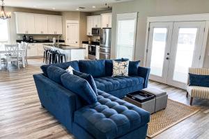 a living room with a blue couch and a kitchen at A Slice of Pura Vida in Mexico Beach