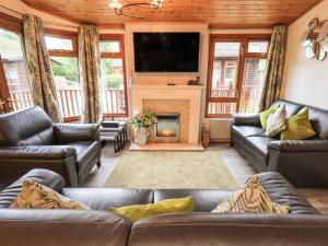 a living room with couches and a fireplace at Cedar Lodge in Windermere