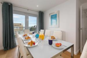 a white dining room table with plates of food on it at Chy Lowen in Carbis Bay