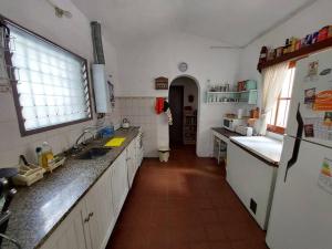 cocina con fregadero y nevera en Casa en Villa Animí (Córdoba) en La Granja