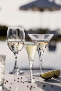 three wine glasses sitting on a table with lime slices at Yria Island Boutique Hotel & Spa in Parasporos