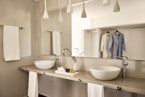 a bathroom with two sinks and a mirror at Yria Island Boutique Hotel & Spa in Parasporos
