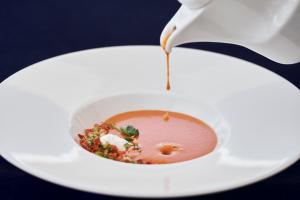 a bowl of soup with sauce being poured into it at Yria Island Boutique Hotel & Spa in Parasporos
