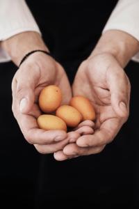 a man holding three brown eggs in his hands at Yria Island Boutique Hotel & Spa in Parasporos