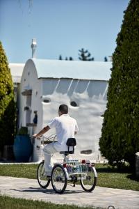 a man riding a bike in front of a church at Yria Island Boutique Hotel & Spa in Parasporos