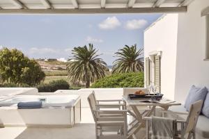 a patio with a table and chairs and a large window at Yria Island Boutique Hotel & Spa in Parasporos