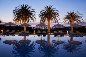 a pool with palm trees and chairs and umbrellas at Yria Island Boutique Hotel & Spa in Parasporos