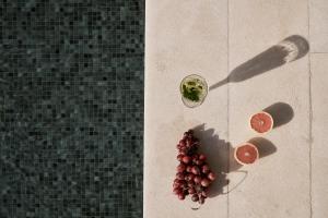 a bunch of grapes on the floor next to a glass at Yria Island Boutique Hotel & Spa in Parasporos