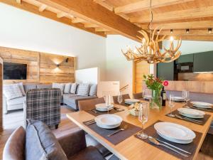 - une salle à manger et un salon avec une table et des chaises dans l'établissement Pinzgau Lodge 1A 1B, à Wald im Pinzgau