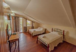 a bedroom with two beds and a desk and a window at Hotel Posada Los Delfines in Bocas del Toro