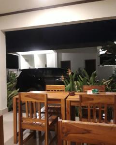 a dining room with a table and chairs and a piano at kamala in Selong Belanak