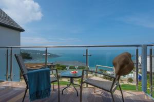 a balcony with a table and chairs and the ocean at Ocean View in Carbis Bay