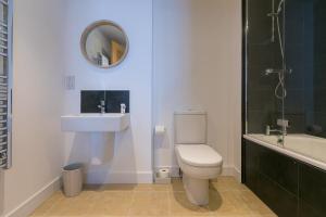 Un baño con inodoro, lavabo y espejo. en Gwel An Chapel, en Carbis Bay