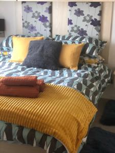 a bed with a yellow blanket and pillows on it at Albatross at Cleethorpes Pearl in Cleethorpes