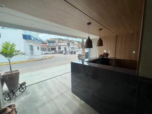 uma cozinha com um balcão preto e uma grande janela em MarBello em Maragogi