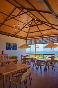 een restaurant met tafels en stoelen en uitzicht op de oceaan bij Prim Hotel Vichayito in Vichayito