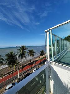 a balcony with a view of the beach and the ocean at Home service na praia de Cabo Branco in João Pessoa