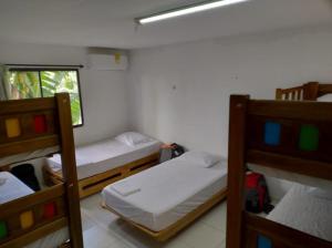 Zimmer mit 2 Etagenbetten und einem Fenster in der Unterkunft Hostal Baruch in Buritaca