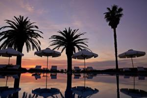 a pool with palm trees and chairs and umbrellas at Yria Island Boutique Hotel & Spa in Parasporos