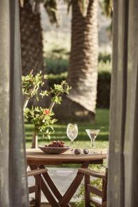 a table with wine glasses and a bowl of fruit on it at Yria Island Boutique Hotel & Spa in Parasporos