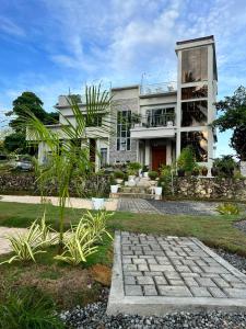 a house with a stone pathway in front of it at D ARC Leisure Home By The Sea in Panglao