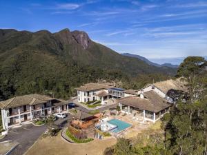 eine Luftansicht eines Hauses mit Bergen im Hintergrund in der Unterkunft Hotel São Gotardo in Itamonte