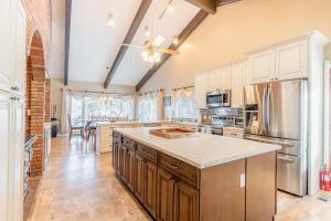 una cocina con armarios blancos y una gran isla en Flathead Lake Villa - Full Property en Lakeside