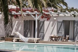 a resort with a pool and a chair and a table at Yria Island Boutique Hotel & Spa in Parasporos