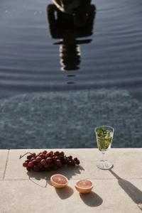 a table with a glass of wine and some fruit at Yria Island Boutique Hotel & Spa in Parasporos