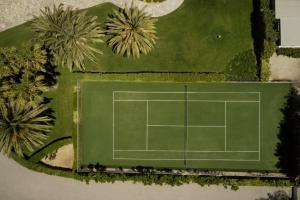 an overhead view of a tennis court with palm trees at Yria Island Boutique Hotel & Spa in Parasporos