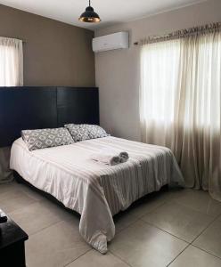 una camera da letto con un grande letto con lenzuola bianche di Casa Magnolia 2 a Ciudad Madero