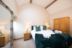 a bedroom with a large bed with green sheets and pillows at Walker's Rest in Buxton