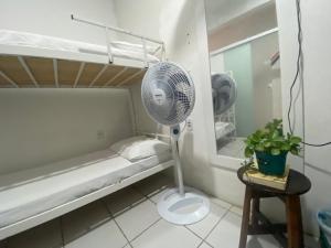 Cette chambre blanche dispose d'un ventilateur et d'un lit. dans l'établissement Guarnicê Hostel, à São Luís