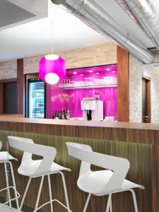a bar with white stools and pink walls at BEST WESTERN Hotel Brussels South in Ruisbroek