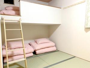 a bunk bed with pink pillows and a ladder at 和縁WAEN in Tokyo