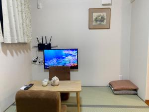 a living room with a table and a flat screen tv at 和縁WAEN in Tokyo