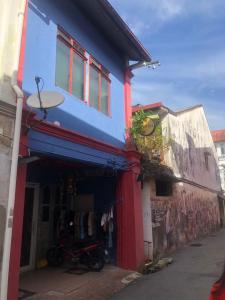 un edificio pintado de azul y rojo en 24 Seven B&B Mamasan en Kuching