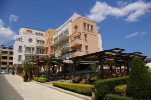 a building with a cafe in front of it at Family Hotel Berlin Beach Sveti Vlas in Sveti Vlas