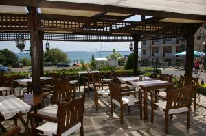 un restaurante con mesas y sillas y vistas al océano en Family Hotel Berlin Beach Sveti Vlas, en Sveti Vlas