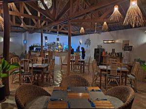 un restaurante con mesas y sillas y un bar en El Nido Coco Resort, en El Nido
