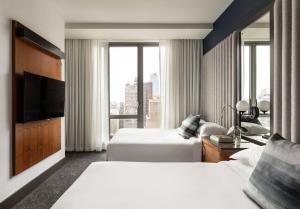 a hotel room with two beds and a television at Kimpton Hotel Eventi by IHG in New York +59 photos
