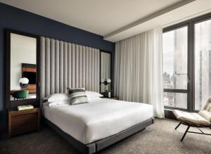 a bedroom with a large bed and a large window at Kimpton Hotel Eventi by IHG in New York +61 photos
