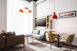 a living room with a couch and chairs and a tv at Staybridge Suites Brighton by IHG in Brighton & Hove