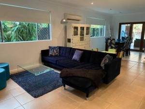 sala de estar con sofá negro y mesa en Tropical Oasis en Freshwater