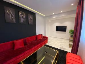 sala de estar con sofá rojo y TV en Corniche Casablanca - Red’s Neuf, en Casablanca