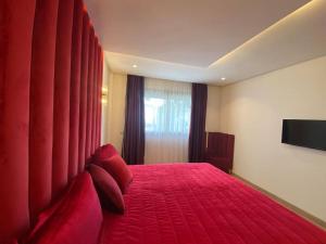 a bedroom with a red bed with red pillows and a window at Corniche Casablanca - Red’s Neuf in Casablanca