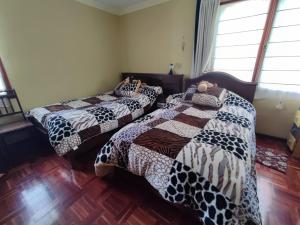 dos camas sentadas una al lado de la otra en una habitación en Familia Heresi ( Casa Kairos), en Cochabamba