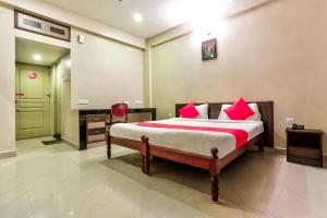 a bedroom with a large bed with red pillows at flagship heavens inn in Chennai